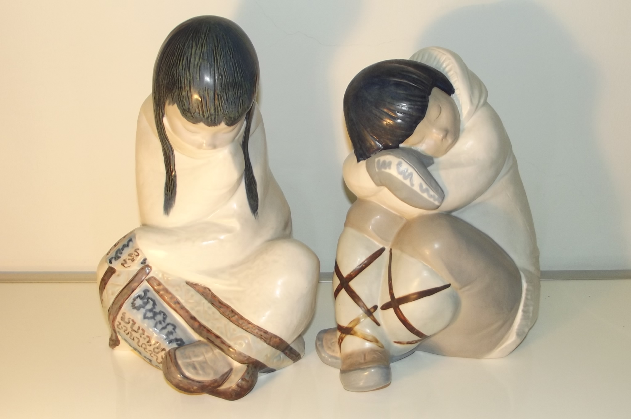 A pair of Lladro figures modelled as huddled Eskimos with one boy and girl. Impressed marks to