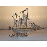 A small silver ornamental ship. 2 inches high