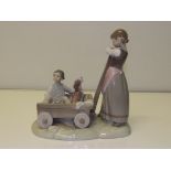 Lladro figure group of girl with a cart containing boy and hound, 21.5cm in height