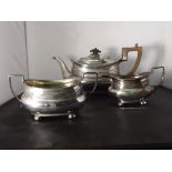 Late Victorian silver three piece tea service of squat form, reeded upper bodies and handles