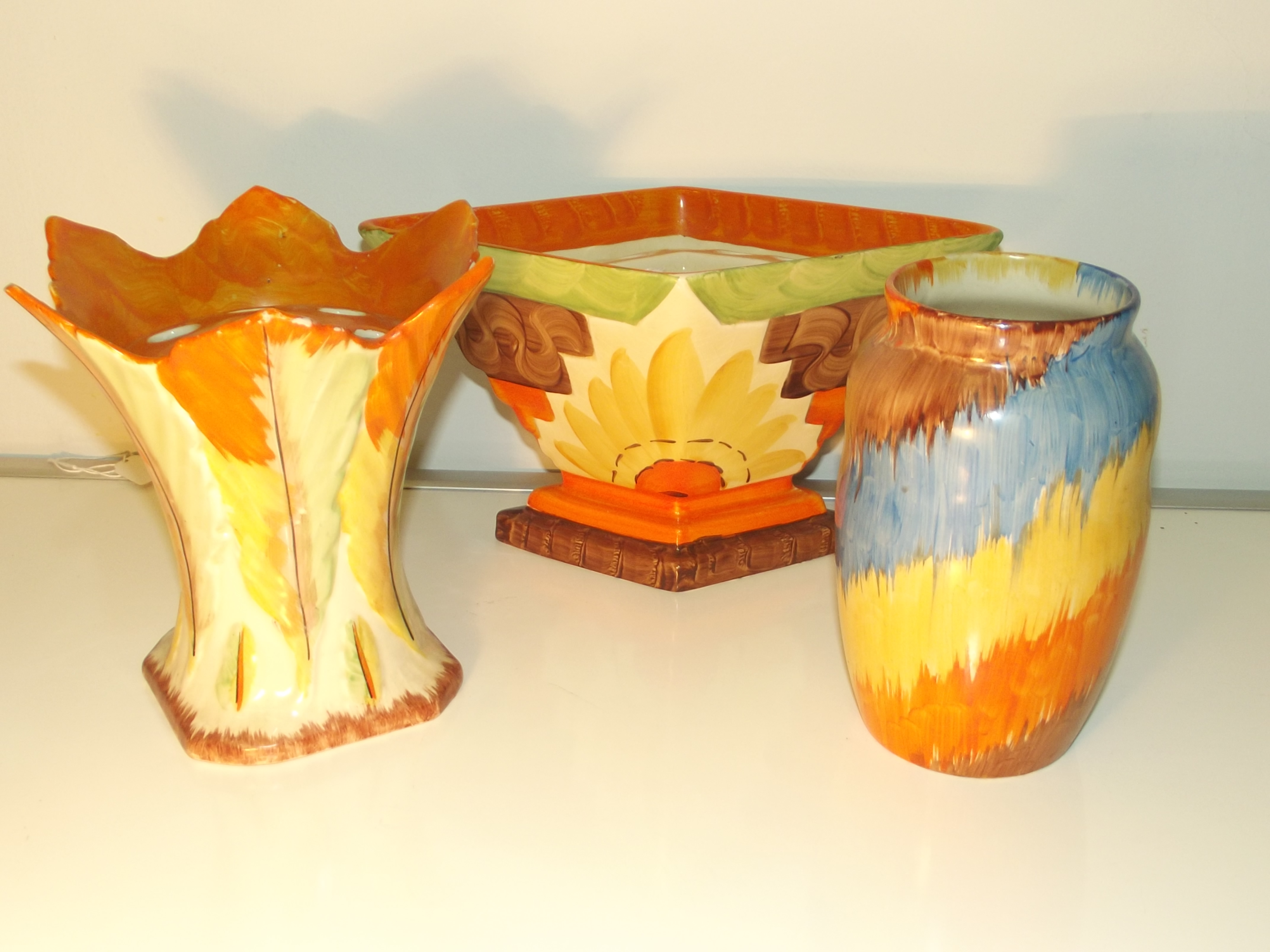 Three colorful art deco pieces of pottery. Two flower boats and a vase. Myott son & co and two