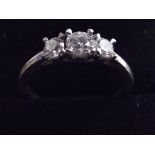 A three stone diamond ring set on a platinum band. Size P half.