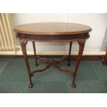 Mahogany oval form centre table, raised stretcher with central finial, gadrooned apron, tapered legs