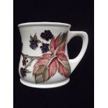 Moorcroft pottery mug , tube lined in the Bramble pattern against an ivory ground impressed