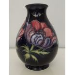 Moorcroft pottery vase, baluster form, tube-lined in the Anemone pattern on a dark blue ground,