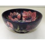 Moorcroft pottery footed bowl, tube-lined in the Anemone pattern against a blue ground, impressed