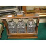 An Edwardian oak three-bottle tantalus w