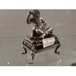 A HM silver figure of a boy sitting on a cushion