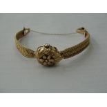 A 14k ladies gold watch with floral lift cover
