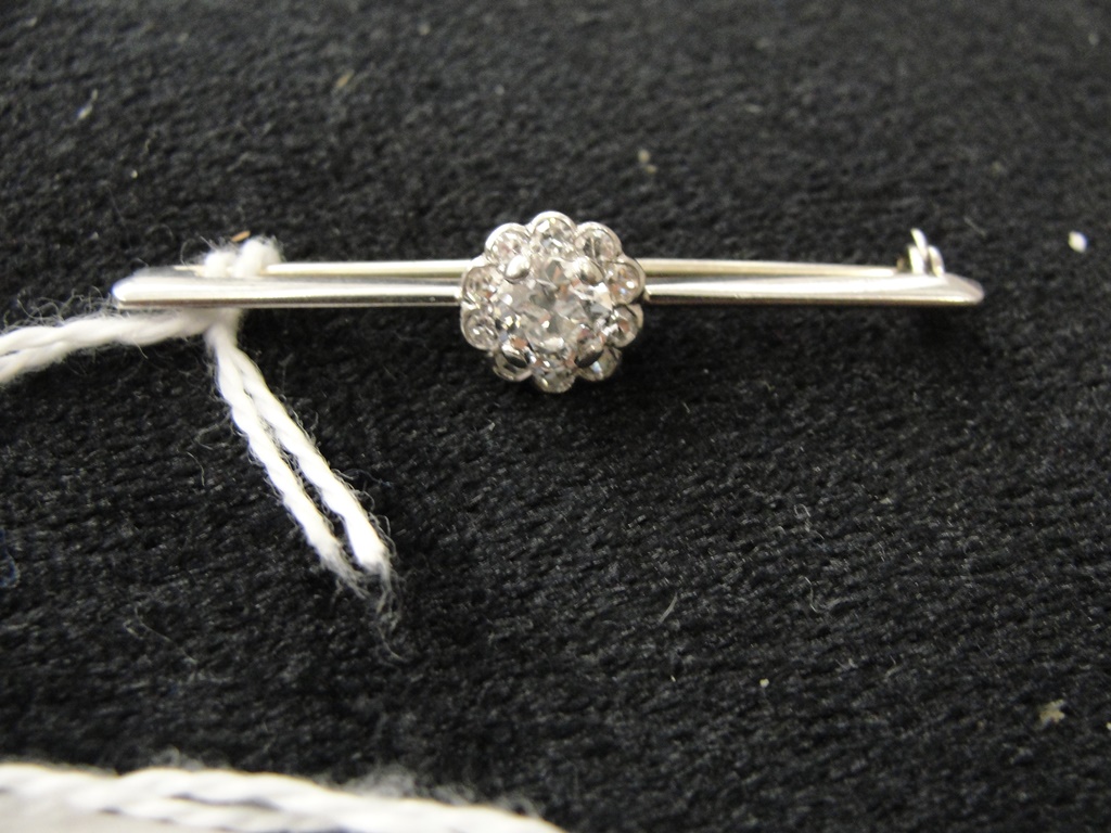 A Diamond Cluster Bar Brooch:
an unhallmarked 18ct gold bar brooch set with a large central old cut - Image 2 of 2