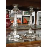 A pair of ornate white metal candlesticks
