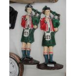 Two painted cast-iron door stops in the form of bagpipers (one A/F)