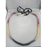 A Ruby and Sapphire Nine Strand Necklace:
with cased Ruby & Sapphire beads strung and twisted in a