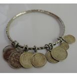 A silver bangle with Maundy coins attached