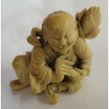 A Meiji period ivory Netsuke of a kneeling man and peach blossom