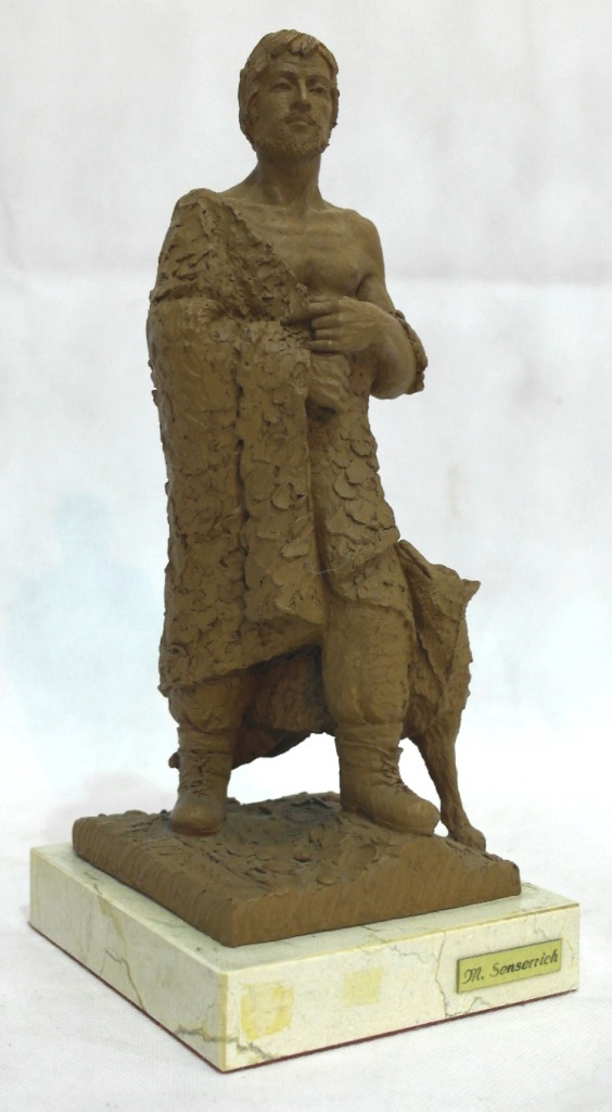 A sculpture of a cloaked man and dog by M Senserrich