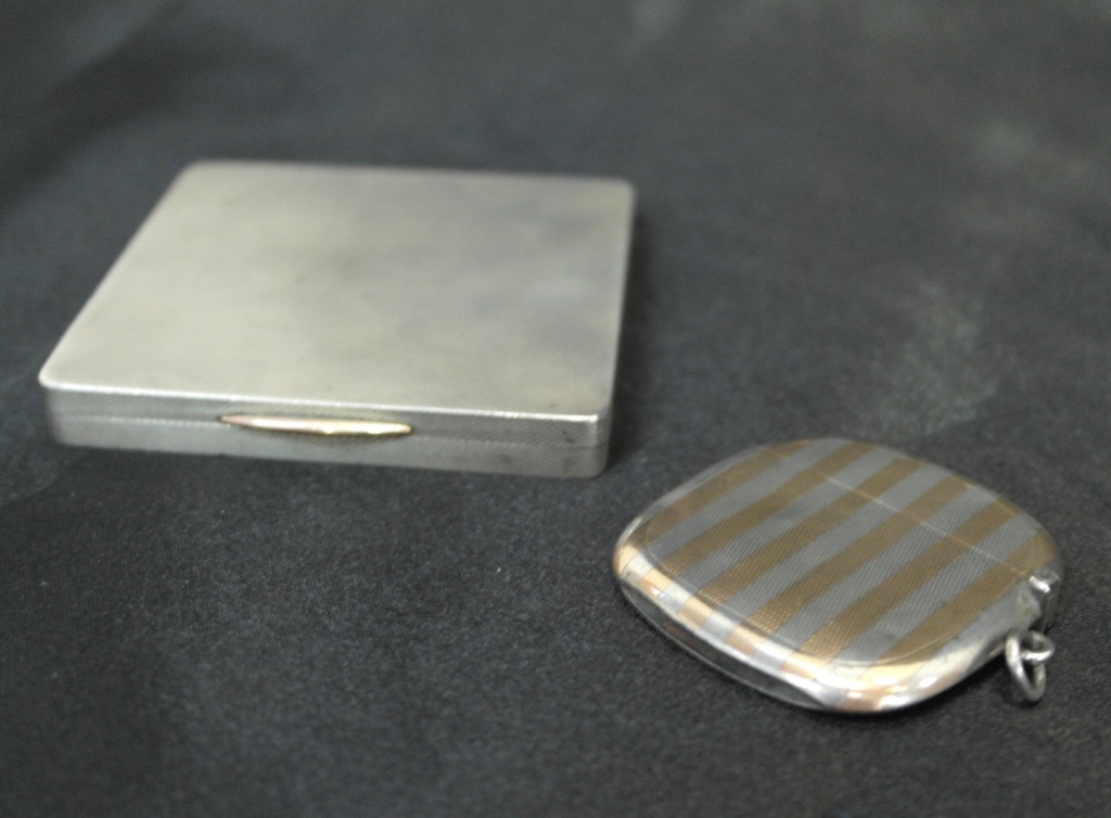 A silver engine turned cigarette case with gold button and Sampson and Mordan gold and silver