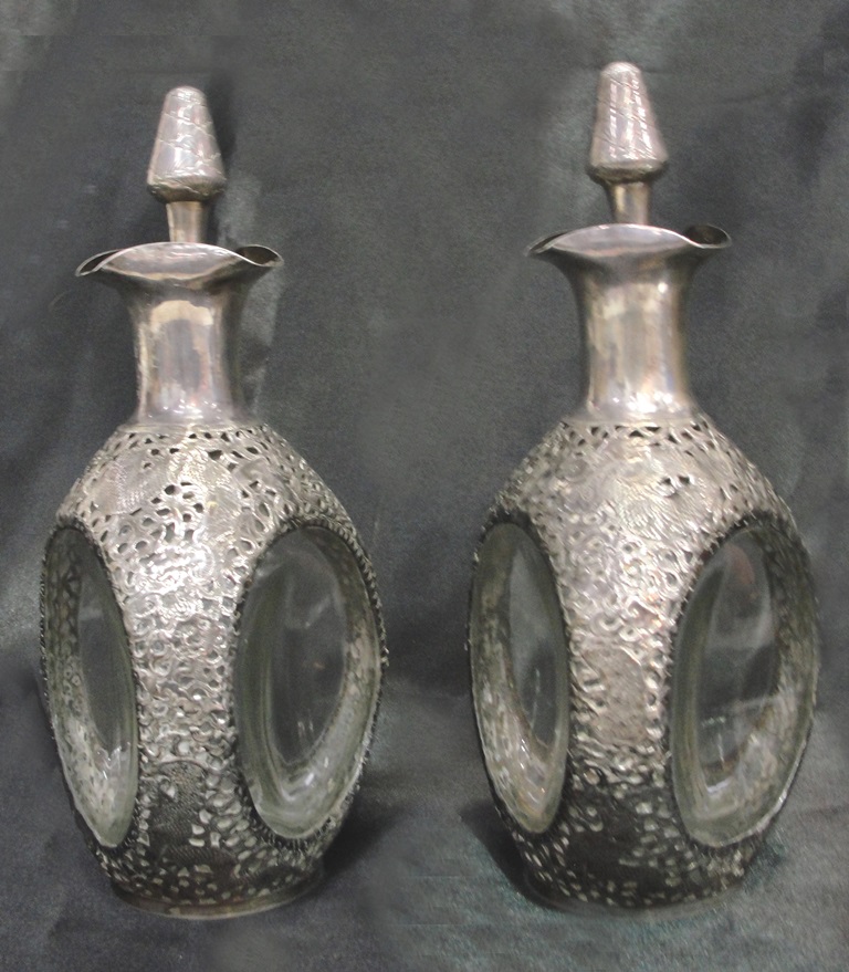 An Unusual Pair of Chinese Silver Mounted 'Dimple' decanters: with filigree work of a dragon,