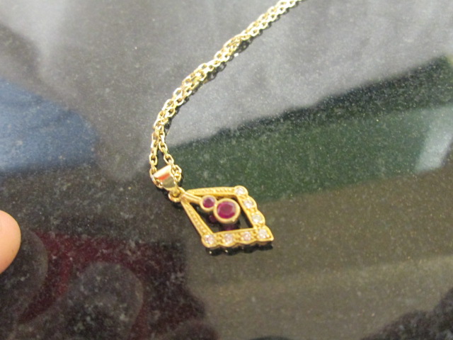 A 9ct ruby and diamond pendant on chain