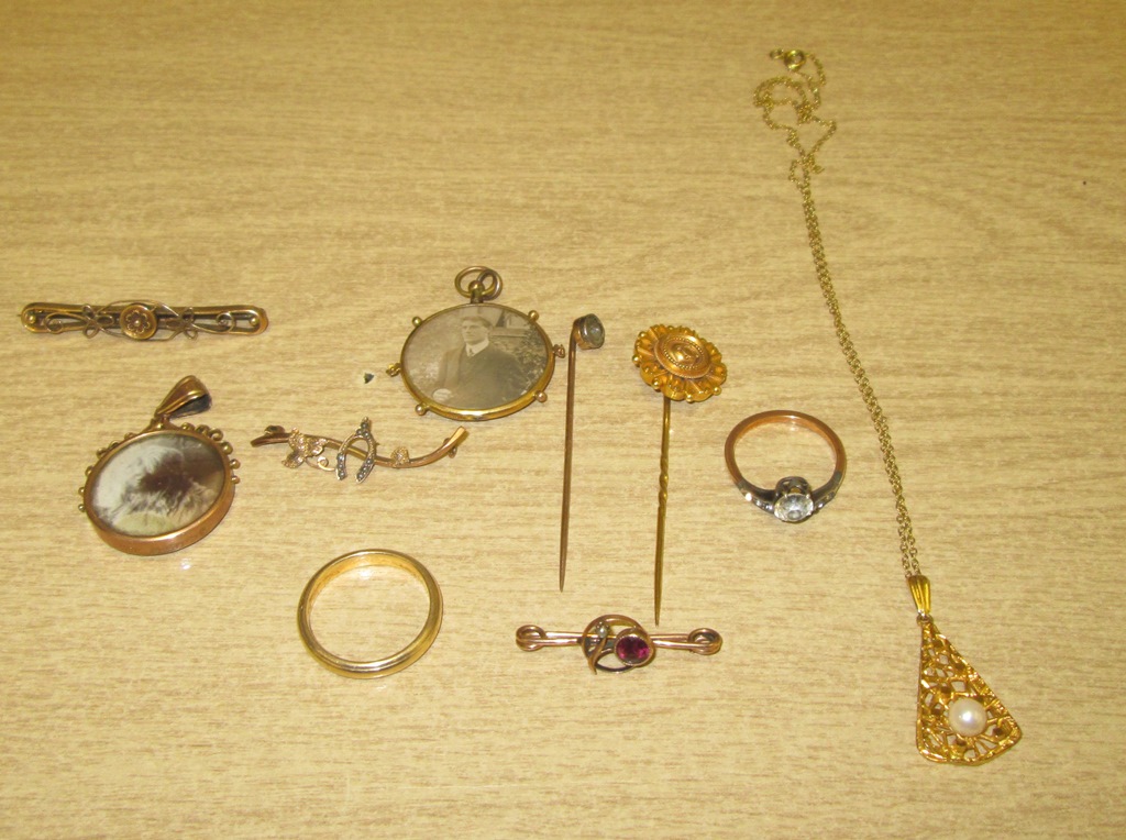 A quantity of 9ct and 15ct brooches and pendants