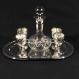 A small decanter four cups and a tray