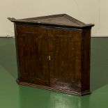 A small mahogany corner cabinet.