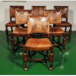 A set of six oak dining chairs with leather covering.