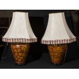 A pair of large table lamps decorated with foliage and shades