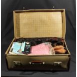 A suitcase containing vintage furs, nylon stockings and other items