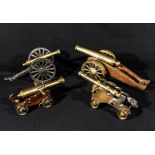 A collection of four vintage bronze cannons on wood carriages