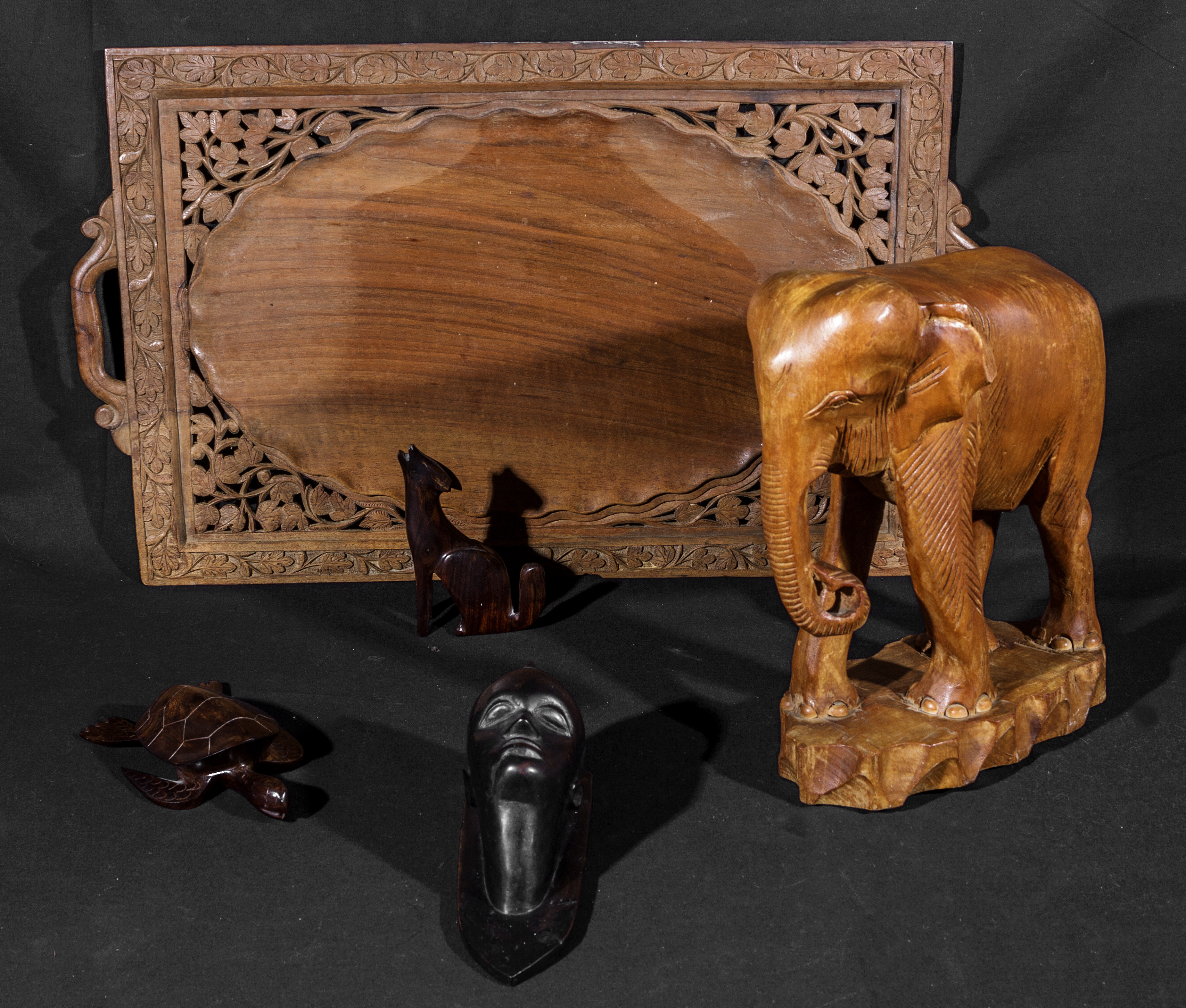 A carved wooden tray, elephant and three others