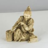 An ivory okimono of a seated man with scrolls, signed