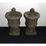 A pair of 18 century stone lidded garden urns .2 ft tall.