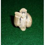 An ivory netsuke of a girl with fan