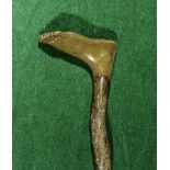 A walking stick with bone handle carved as a foot