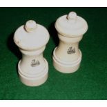 A pair of ivory pepper grinders