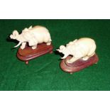 A pair of ivory elephants on wooden bases