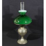 An oil lamp with green glass shade