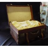 A vintage suitcase containing linen and lace