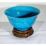 A Chinese blue ground bowl on carved wood stand