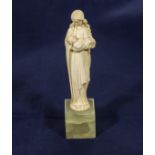 A carved ivory figure of a mother and child on onyx base