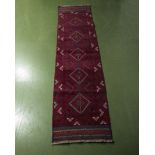 A hand knotted woolen red ground runner, 62cm x 249cm