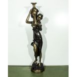 A bronzed figure of a lady carrying an urn