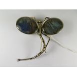 An arts and crafts white metal brooch in the form of a dragonfly, the wings set with butterfly wings