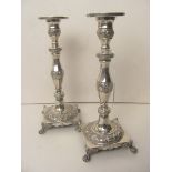A pair of continental silver candlesticks having cast foliate borders on raised lion paw feet