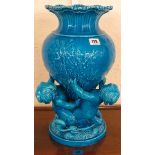 Minton turquoise glazed vase decorated with seaweed design, supported by three putti on a circular