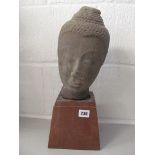 Asian carved sandstone head on later wooden stand