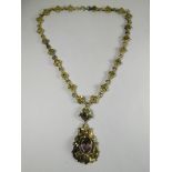 A white metal necklace of ornate styalized design with fancy link chain and a multi gem set pendant,