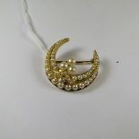 A Victorian yellow gold crescent brooch set with split seed pearls and a single mine cut diamond