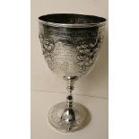 A large late 19th century silver goblet having all over embossed decoration, with inscription, 9"